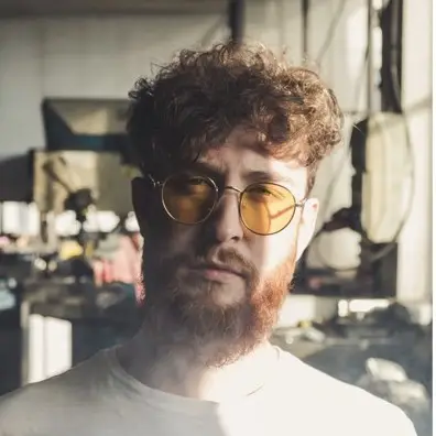 Barber 1 young man with beard smiling and wearing a  brown shirt